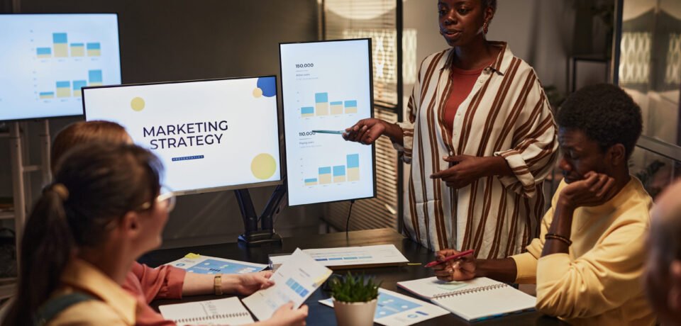 Black Woman Presenting Plan At Meeting What is the impact of voice search on online marketing strategies?
