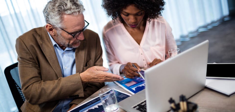 Two businessmen working on a computer at office