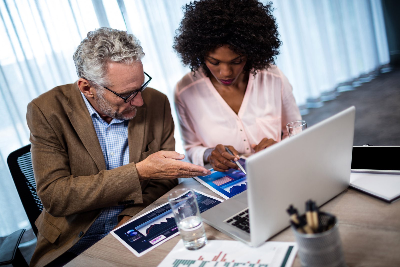 Two businessmen working on a computer at office