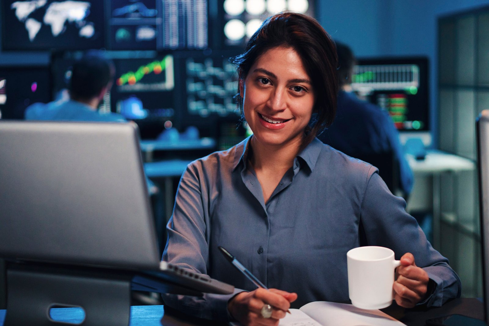 Young business female or broker working on finance trading with laptop computer. Investiment woman looking at camera at office. Economy concept. High quality photo