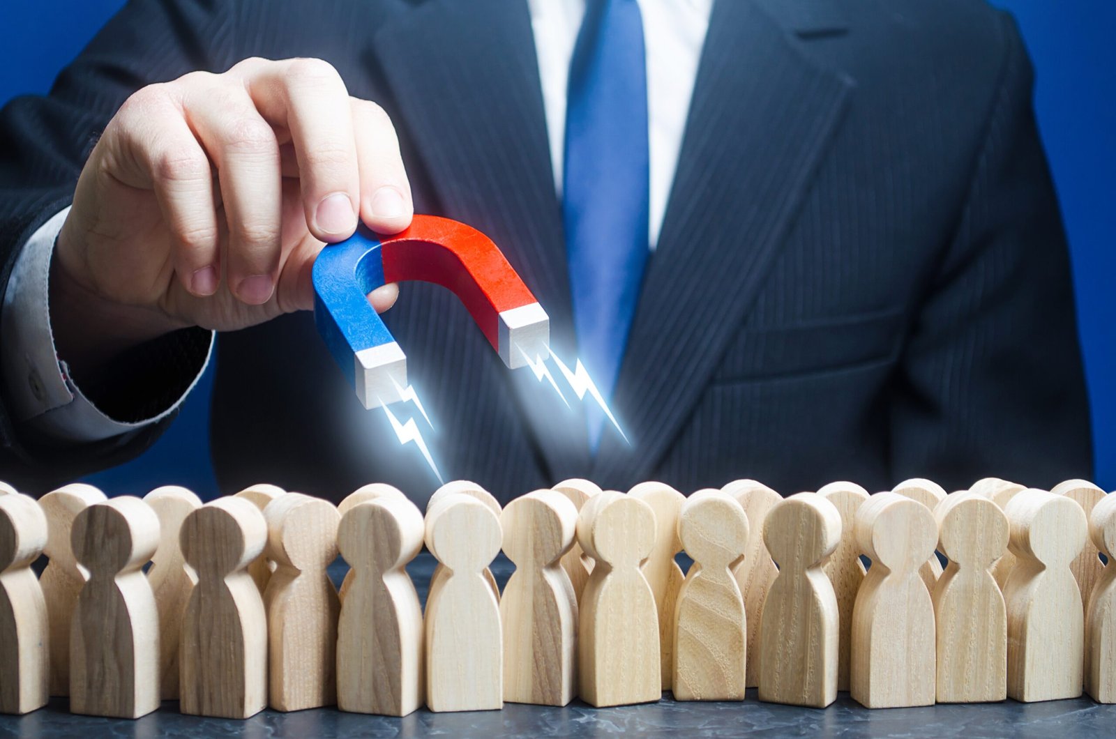 Man with a magnet is in search of candidates for work among the crowd. Recruiting talented workers, headhunters, human resources. Best choice. Search professionals specialists for open vacancies.