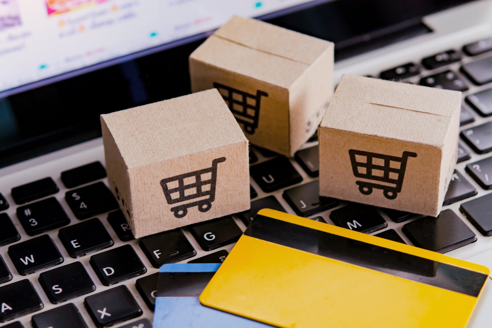 Shopping online. Credit card and cardboard box with a shopping cart logo on laptop keyboard. Shopping service on The online web. offers home delivery