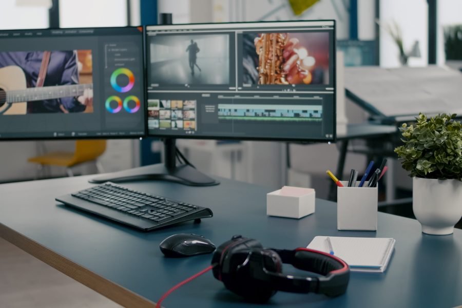 Empty creative multimedia studio with professional computer placed on desk Empty creative multimedia studio with professional computer placed on desk, dual monitor setup. Video editing start up company agency with no people in it and post production software on pc displays