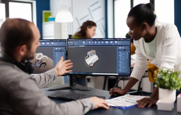 Diverse team of engineer architects working on modern cad program Diverse team of engineer architects working on modern cad program developing construction metalic components. Industrial designer studying prototype idea on pc showing digital software with gears