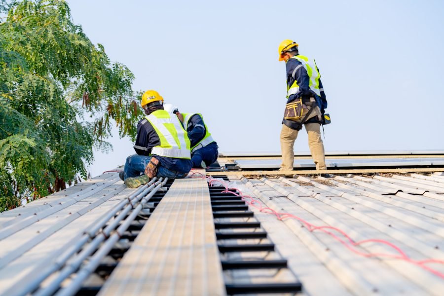 workers installing solar panels, for efficient energy on rooftop Solar cell farm power plant eco technology.landscape of Solar cell panels in a photovoltaic power plant.concept of sustainable resources and renewable energy.blue tone.